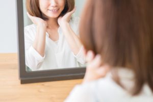 鏡を見る女性のイメージ画像